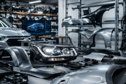 Farol automotivo moderno sobre bancada em oficina especializada, cercado por peças de lataria e componentes de reposição em ambiente industrial tecnológico e organizado.